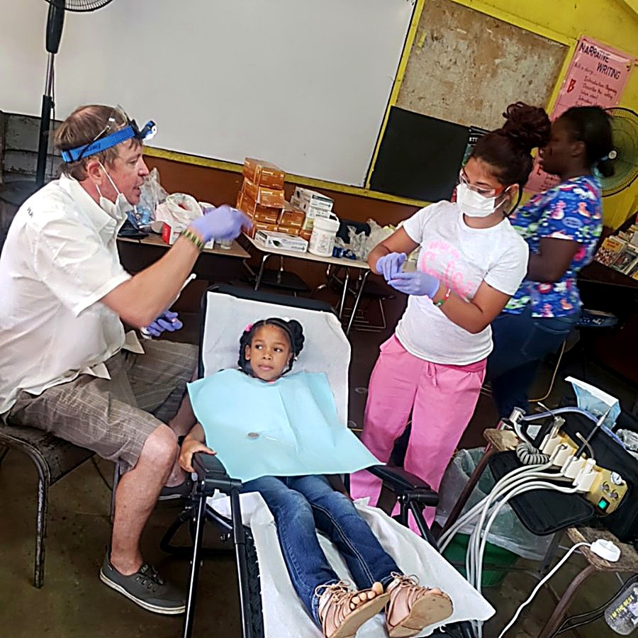 Dr. Will and assistants treating a young patient during a clinic day