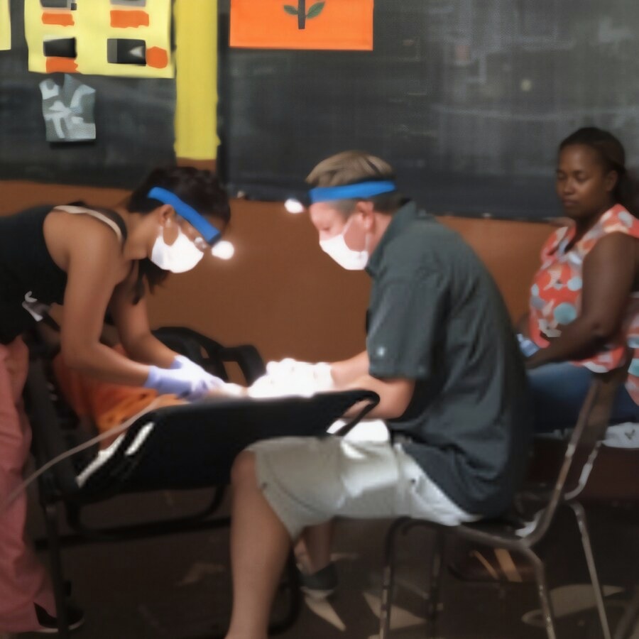 Dr. Will and a team member treating a patient in the classroom clinic
