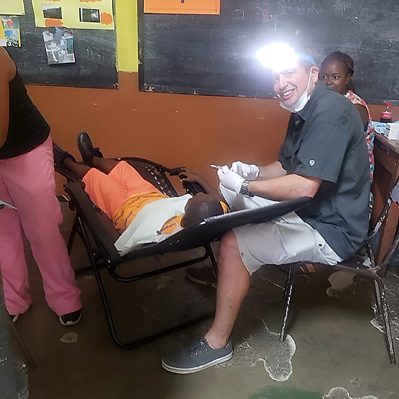 Dr. Will treating a patient by headlamp
